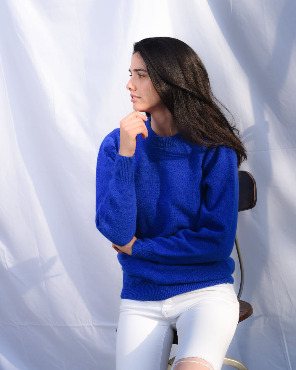 Woman wearing a blue knitted jumper and white jeans