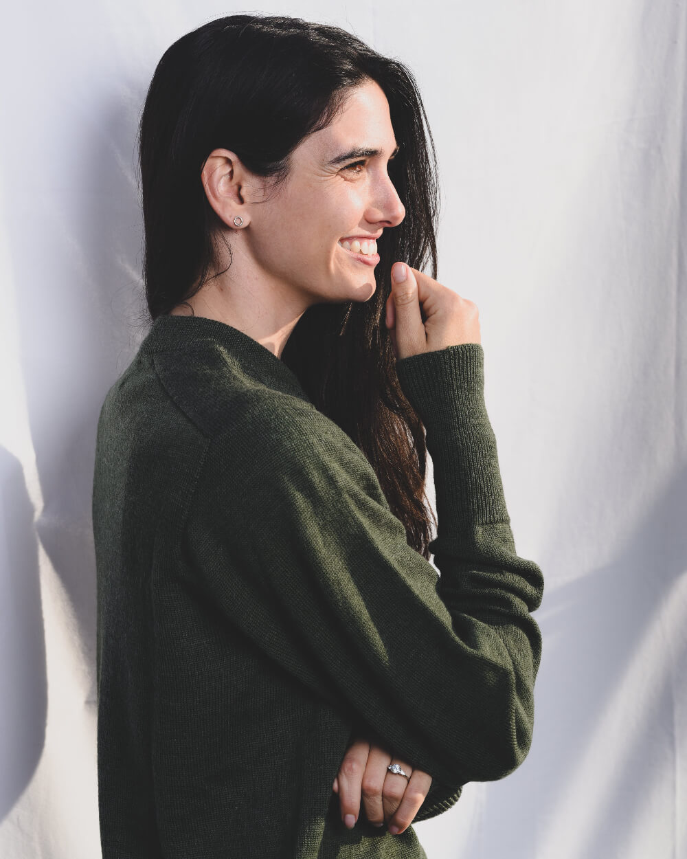 Woman wearing a green sweater against a white background