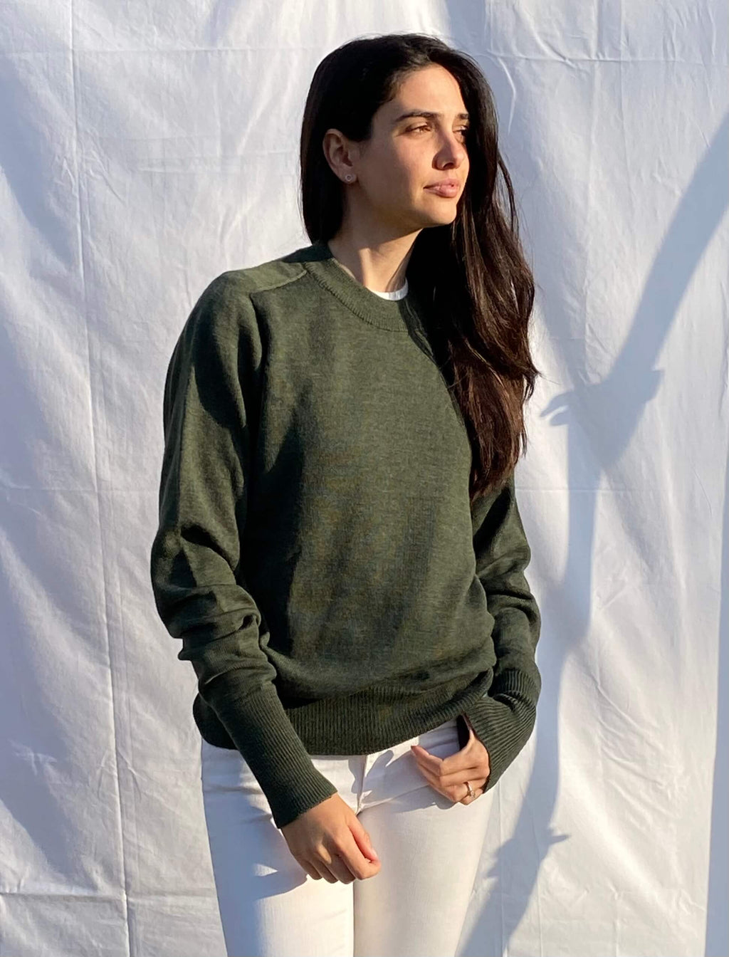 Person wearing a green merino wool sweater