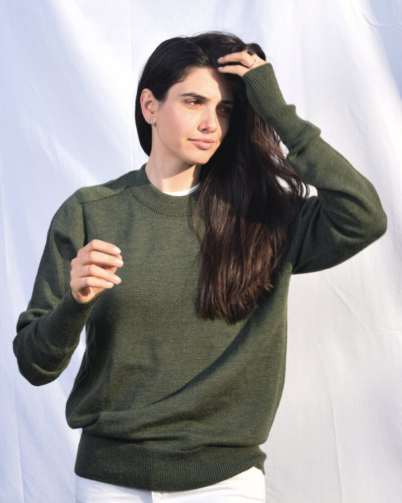 Woman wearing a green sweater against a white background